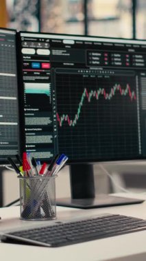 Modern dekor firması ofisinde şamdan grafiklerini gösteren dikey video monitörleri. Borsa analizi ve strateji planlaması için kullanılan ticari şirket çalışma masası kurulumu