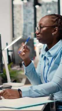 Borsa hisseleri üzerine araştırma yapan donanım firması ofisindeki dikey video finans analisti. Borsa şirketi profesyonel okuma yatırım analizi raporları bilgisayar monitöründe ticaret yapmak için