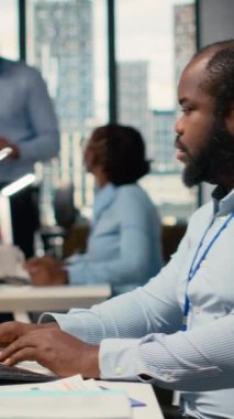 Pervane firması ofisindeki dikey video portföy yöneticisi yatırım iadelerini artırmak için borsa eğilimlerini analiz eder. Afrikalı Amerikalı erkek yatırım fırsatlarını belirlemek için performans ölçümlerini izliyor