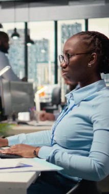 Beklenmedik piyasa çöküşünden sonra yatırım portföyü şamdan grafiklerine bakarken suratını asan dikey video tüccarı. Afro-Amerikalı kadın borsa kayıpları ve kamera A 'dan rahatsız oldu.