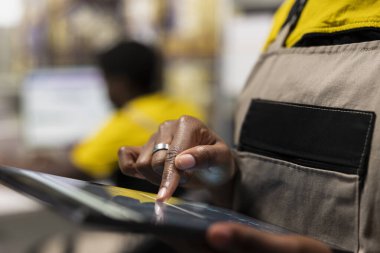 Tabletteki e-ticaret envanter sisteminde, depolama dağıtım protokollerini denetleyen kadın çalışanları kapatın. Pürüzsüz kargo hareketi için lojistik planlama.