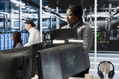 Yazılım geliştiricisi veri yoğunlaştırılmış işlemler yapan sunucu kümelerini denetliyor. Makine öğrenimi için depolama sağlayan süper bilgisayarları denetlemek için dizüstü bilgisayar kullanan bilişim uzmanı