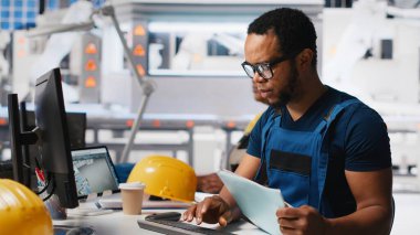 Siyah mühendis, alternatif enerji için güneş paneli tasarımları üreterek, güneş fabrikası yazılımında otomasyon mantığı uyguluyor. Yüksek teknoloji üretim hattı. Kamera A.