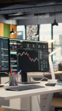 Modern dekor firması ofisinde şamdan grafiklerini gösteren dikey video monitörleri. Borsa analizi ve strateji planlaması için kullanılan ticari şirket çalışma masası kurulumu