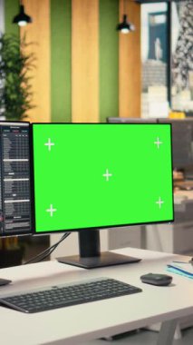 Özel şirket ofisindeki yeşil ekranda görüntülenen dikey video borsa ölçümleri. Forx şirketinin çalışma alanındaki masaüstü kurulumu, finansal istatistikler model bilgisayardan görülebilir