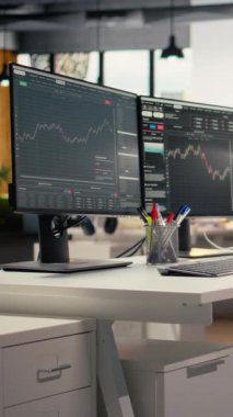 Özel firma ofisinde bilgisayar ekranlarında şamdan grafikleri olan dikey video ticareti yazılımı. Finansal uzmanlar tarafından kullanılan masaüstü bilgisayarları analitik kullanarak borsa faaliyetlerini izliyor