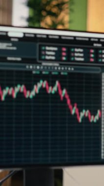 Özel firma ofisinde bilgisayar ekranlarında şamdan grafikleri olan dikey video ticareti yazılımı. Finansal uzmanlar tarafından kullanılan masaüstü bilgisayarları analitik kullanarak borsa faaliyetlerini izliyor