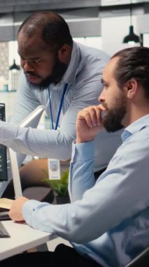 Dikey video prop firması personeli PC masasında düzgün ticari işlemler için iletişim kuruyor. İşletmecilerden oluşan bir ekip beyin fırtınası yapıyor, pazar eğilimlerini ve portföy pozisyonlarını tartışıyor.