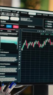 Yatırım şirketinin ofisindeki bilgisayar monitörlerinde sergilenen borsa ölçümlerinin dikey videosu. Canlı finansal verileri görünür olan varlık yönetimi şirketinde çalışma istasyonu