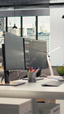 Yatırım şirketinin ofisindeki bilgisayar ekranlarında gösterilen dikey video borsa ölçümleri. PC monitörlerinde canlı finansal verileri olan komisyon şirketinin işyerindeki çalışma istasyonu
