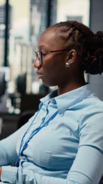 Borsa ofisindeki dikey video portföy yöneticisi, geri dönüşleri artırmak için borsa eğilimlerini analiz eder. Afrikalı Amerikalı kadın yatırım fırsatlarını belirlemek için borsa ölçümlerini izliyor