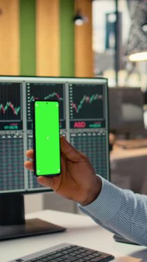 Pervane firması ofisindeki dikey video tüccarı yeşil ekran cep telefonu kullanarak sanal toplantıya katılıyor. İnternet telekonferansına katılmak için krom anahtar cep telefonu kullanan Afro-Amerikalı bir adam iş başında.