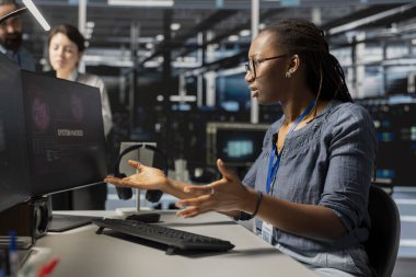 Sunucu çiftliğinde çalışan kadın siber güvenlik sistemleri tarafından tespit edilen kötü niyetli tehditlerle tedirgin olmuş. Düzensiz ağ etkinlikleri tespit ettikten sonra endişelenen stresli veri merkezi sistem yöneticisiName