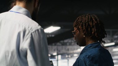 Nöro ağ kodunu ve LLM görselleştirme panellerini inceleyen mühendis tarafından yapılan işi denetleyen sunucu çiftlik yöneticisi. Ekip lideri AI sistem performansını izleyen işçi denetliyor