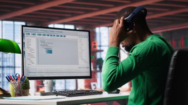 Teknolojiden anlayan siyah mühendis evde güvenli çevrimiçi program geliştiriyor. İkili verilerle çevrili olan serbest çalışan arayüz tasarımı, senaryo optimizasyonları ve ağ sistemleri üzerinde çalışıyor. Kamera A.