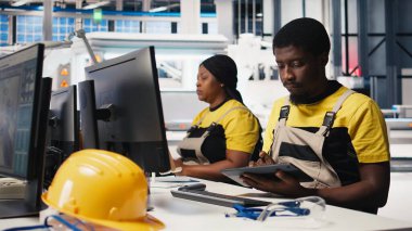 Siyah mühendis güneş paneli üretiminde yenilenebilir enerji fotovoltaik sistemlerini artırmak için PC yazılımı üzerinde çalışarak güç optimizasyonu modelleri geliştiriyor. Çevre dostu endüstri. Kamera B.