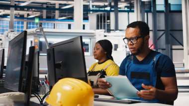 Siyah mühendis, alternatif enerji için güneş paneli tasarımları üreterek, güneş fabrikası yazılımında otomasyon mantığı uyguluyor. Yüksek teknoloji üretim hattı. Kamera B.