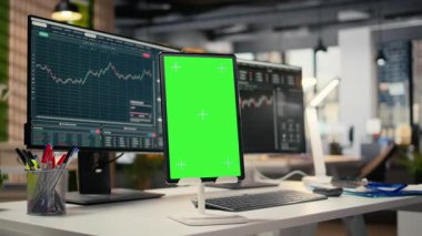 Günlük ticaret için kullanılan komisyon şirketinin iş yerindeki yeşil ekran tabletini kapatın. PC 'deki borsa portföy hisseleri, tescilli firma ofisindeki kroma anahtar cihazının yanında