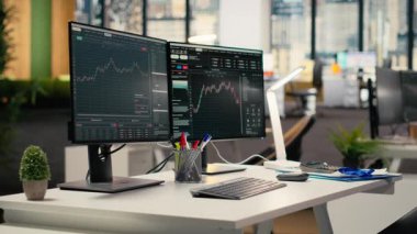 Tescilli firma ofisinde borsa grafiklerini gösteren bilgisayar ekranları. Borsa analizi ve strateji planlaması için kullanılan komisyon işi çalışma masası kurulumu