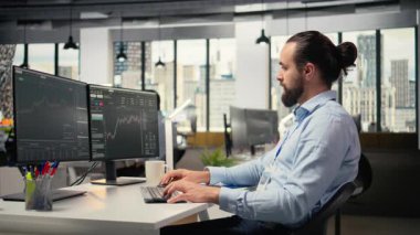 Gülümseyen bir borsa simsarı kısa vadeli piyasa dalgalanmalarından yararlanmak için hisse alıp satıyor. Fiyat tablolarını kullanarak hızlı kar olanaklarını belirleyen neşeli bir finans uzmanı, kamera A