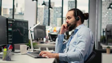 Ofisteki mali danışman müşterilerle canlı görüşmelerde kişisel yatırım rehberliği sunuyor. Danışman mikrofonla konuşuyor, müşterilere özel portföy yapımında yardım ediyor, kamera B