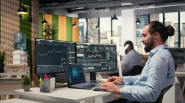 Ofisteki tüccar, şemaları yorumlamak, satın alma ve satışı optimize etmek için dizüstü bilgisayardaki yapay zekayı kullanıyor. Borsacı, kâr ve kamera A 'yı maksimuma çıkarmak için defterde derin öğrenim otomatikleştirmesi kullanır.