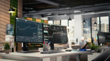 Yatırım fonu ofisindeki bilgisayar ekranlarında sergilenen borsa ölçümleri. Finansal yazılım arayüzü önx şirketinin çalışma alanında görünür olan masadaki bilgisayar monitörleri