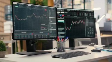 Bilgisayar monitörleri modern dekor firması ofisinde şamdan grafiklerini gösteriyor. Borsa analizi ve strateji planlaması için kullanılan ticari şirket çalışma masası kurulumu