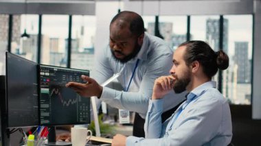 Aksesuar firması personeli, ticari işlemleri kolaylaştırmak için bilgisayar masasında iletişim kurar. Ofisteki tüccarlar beyin fırtınası yapıyor, pazar eğilimlerini ve portföy pozisyonlarını tartışıyorlar, kamera B