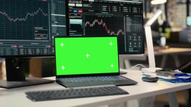 Yeşil ekran dizüstü bilgisayarı ve varlık yönetimi ofisindeki ticaret uygulamasını kapatın. Borsa faaliyetlerini analitik araçlarla takip eden komisyoncu firma çalışanlarının masasında kullandığı model cihazı