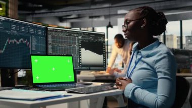 Ofisteki aksesuar firması, izole ekran dizüstü bilgisayarında video dersinden yeni ticaret stratejileri öğreniyor. Forx Şirketi 'ndeki Afrikalı Amerikalı kadın. Model defter, kamera A kullanıyor.