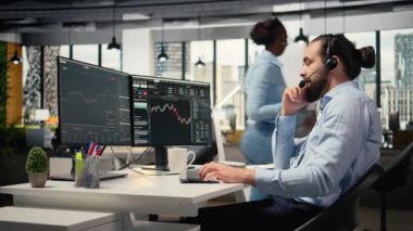 Ofisteki mali danışman müşterilerle canlı görüşmelerde kişisel yatırım rehberliği sunuyor. Danışman mikrofonla konuşuyor, müşterilerin özel portföy yapmalarına yardım ediyor, kamera A