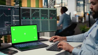 Portföy yöneticisi, yatırım iadesi elde etmek için izole edilmiş ekrandaki pazar eğilimlerini analiz ediyor. Çalışan, yatırım olanaklarını belirlemek için krom anahtar defterdeki performans ölçümlerini takip ediyor, kamera A