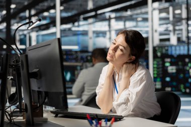 Tükenmiş sunucu çiftliği bilişim uzmanı bilgisayar ekranına uzun süre baktıktan sonra boynu tutulmuş. Veri merkezindeki yorgun sistem yöneticisi, uzun donanım sorun çözme oturumuyla vurguladı