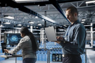 Bilgisayarda hata ayıklama makinesi öğrenen teknisyenlerden oluşan bir sunucu ekip, yapay zeka otomatikleştirmesi yapıyor. Veri merkezi programcısı ve iş arkadaşı sinirsel ağları optimize ediyor, derin öğrenme modellerini ayarlıyor