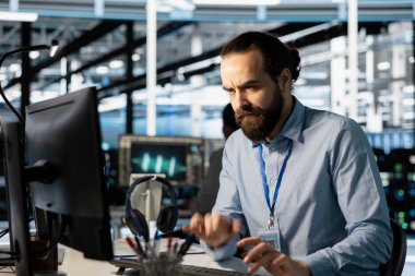 Sunucu merkezi çalışanı, analiz sırasında yapılan altyapı hatalarından dolayı endişeli. Veri merkezindeki sinir bozucu yazılım geliştirici beklenmedik ağ kesintisi tespit ettikten sonra PC monitörüne kaşlarını çatıyor