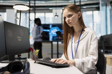 İş yerindeki derin öğrenme algoritmalarını ayarlarken kritik hata uyarısı gören kadın teknisyen. AI ile çalışırken arıza alarmı alan genç işçiler