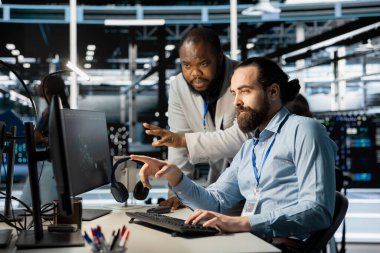 Sistem yöneticilerinden oluşan bir ekip sunucu çiftliğinde bilgisayar kullanarak verileri analiz ediyor. Veri merkezi meslektaşları beyin fırtınası yapıyor, ekipmanları inceliyor, sistem bütünlüğü ve güvenliğini sağlıyorlar