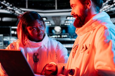 Yörüngedeki meslektaşlar beyin fırtınası yapıyor, kırmızı ışık sorununu çözmek için dizüstü bilgisayar kullanıyorlar. Uzay gemisi mühendisleri, operasyonları etkileyen hasarlı ekipman bileşenlerini tamir etmek için dizüstü bilgisayar kullanıyor.