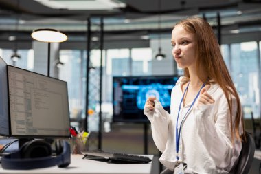 İş yerindeki derin öğrenme algoritmalarını kullanarak otomatikleştirmeyi kutlayan neşeli bayan teknisyen. Kod optimizasyonu için yapay zeka kullanan genç kız memnun oldu.