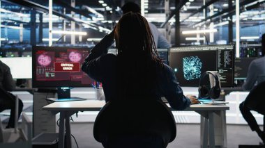 Arızalı veri analizi yapay zeka jeneratöründen endişelenen stresli sunucu merkezi yönetimi. Sistem ölçümlerini gösteren yapay zeka aracındaki kritik hata nedeniyle endişeli veri merkezi çalışanı, kamera A