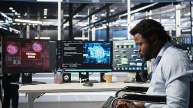 Veri merkezinde belden aşağısı felçli mühendis yapay zeka ağacı yazılımı hatası yüzünden panikledi. Tekerlekli sandalyedeki endişeli sunucu merkezi çalışanı görsel programlama aracı arızası yüzünden endişeli, kamera A