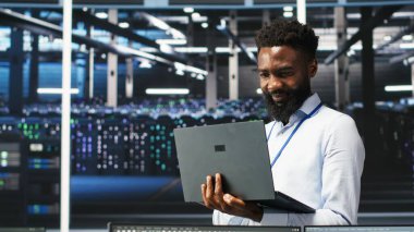 Happy Veri Merkezi Yöneticisi dizüstü bilgisayarda düğüm ağacı programlama kullanır, iş arkadaşıyla beşlik çakar. Gülümseyen sunucu tarla işçisi iş arkadaşını selamlıyor, veri analiz grafiğini inceliyor, kamera B