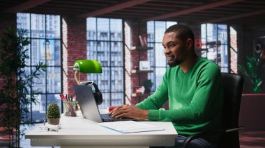 Bilgisayarda hesap tablolarını tamamlayan Afrikalı Amerikalı erkek tele-işçi hücrelere sayısal verileri giriyor ve toplamları hesaplıyor. Yazılım işlevlerini kullanan bir adam. Kamera B.