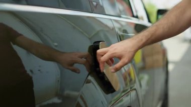 Sürücünün, iskele kapağını açıp şarj pilini şarj etmek için elektrik kablosu konnektörünü taktığı yeri kapatın. Adam, EV otomobilinin araç giriş portunu elektrik sağlamak için açıyor, yakınlaştırın