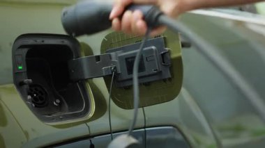 Elektronik kablo bağlantısını EV araç aküsüne bağlayan sürücünün iskele güç motorunu şarj etmesini kapatın. Kişi çevre dostu güç kaynağına takılarak pili şarj etmek için EV otomobil giriş portunu açar