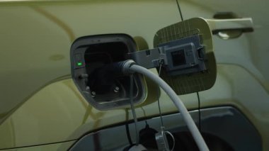 EV 'ye bağlı şarj cihazının kapatılması, sıfır karbon ayak izi teknolojisi kavramı. Elektrikli otomobil elektrik santralinde şarj ediliyor, sürdürülebilir ulaşım gösteriliyor