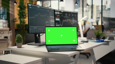 Forx firmasının ofisindeki yazılımı yeşil ekran dizüstü bilgisayarında grafiklerle kapat. Finansal uzmanlar tarafından kullanılan, analitik araçlar kullanarak borsa faaliyetlerini takip eden masandaki maket defteri.