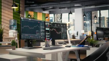Bilgisayar monitörleri modern dekor firması ofisinde şamdan grafiklerini gösteriyor. Borsa analizi ve strateji planlaması için kullanılan ticari şirket çalışma masası kurulumu