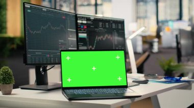 Forx firmasının ofisindeki yazılımı yeşil ekran dizüstü bilgisayarında grafiklerle kapat. Finansal uzmanlar tarafından kullanılan, analitik araçlar kullanarak borsa faaliyetlerini takip eden masandaki maket defteri.